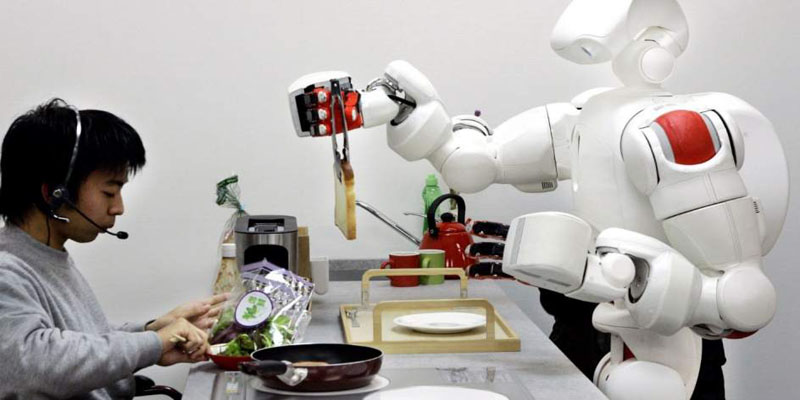 Robot y humano interactuando en una mesa de cocina. 